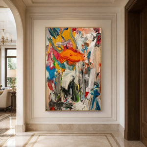 Gold framed multicolored abstract artwork on a paneled wall in a stone hallway.