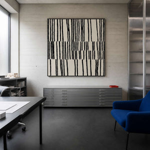 Black framed patterned artwork above metal drawing cabinets in a creative studio.