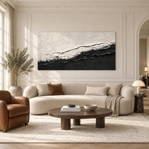 Black-and-white textured abstract above a cream sofa and oval brown coffee table.