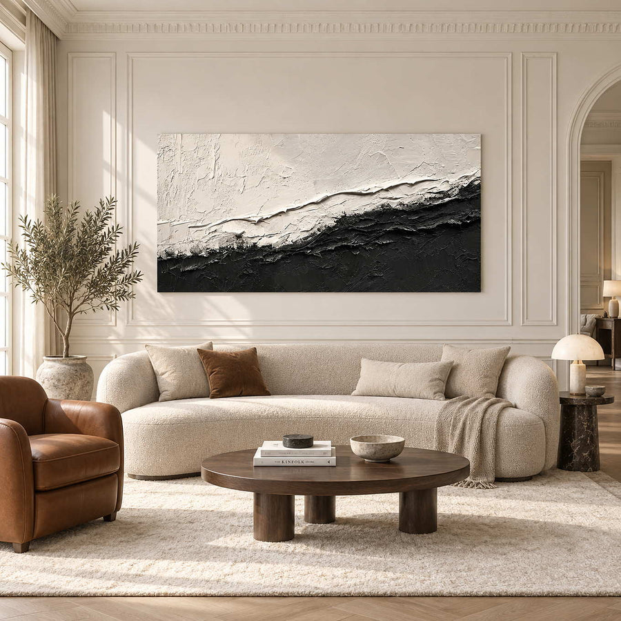 Black-and-white textured abstract above a cream sofa and oval brown coffee table.