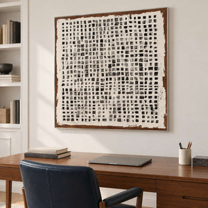 Grid painting above a wooden desk and dark office chair.