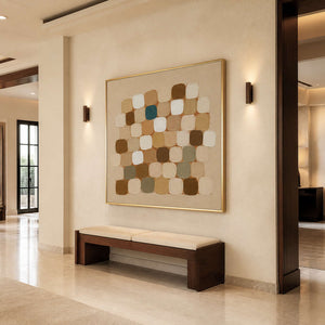 Gold framed abstract squares above a wooden hallway bench between warm wall lights.