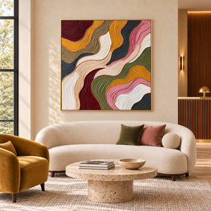 Love in Motion in a gold frame above a curved cream sofa beside a mustard lounge chair in a commercial lobby.