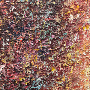 Close-up of rust-red, dark brown and turquoise fragments across a rough raised surface.