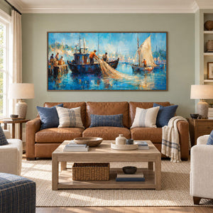Hand-painted harbor scene with fishermen, sailboats, and luminous blue water, displayed in a living room in a brown wood frame.