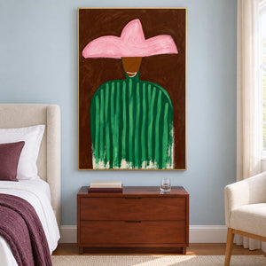Pink and green figure artwork above a brown bedside chest on a pale blue wall.