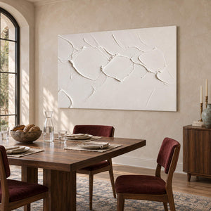 Chalk-white abstract relief painting with raised irregular seams without an outer frame in a dining room.