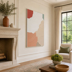 White-framed textured abstract wall art beside a stone fireplace and sunlit living room window.
