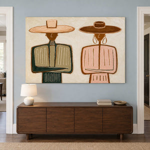 Wide two-figure art above a dark wooden sideboard.