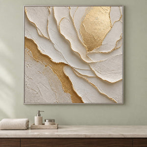 Hand-painted sculptural flower in layered ivory, white, and warm gold, displayed in a bathroom dry area in a silver frame.
