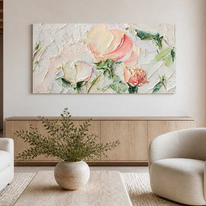 Frameless floral artwork above a pale sideboard behind cream living room chairs.