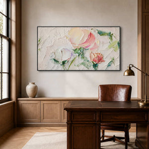 Black framed floral artwork behind a walnut desk and leather chair in a study.