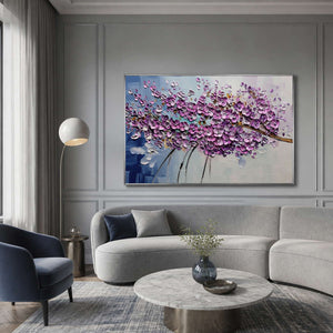 Lilac blossom artwork displayed above a cool gray living room sofa.