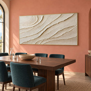 Panoramic ivory abstract wall art with layered flowing relief, displayed in a dining room in a gold frame.
