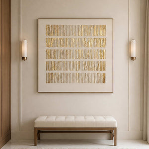 Wood framed cream and gold abstract artwork above an upholstered bench between sconces.
