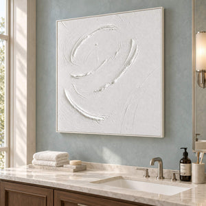 White minimalist relief painting with raised circular gestures in a white frame beside a bathroom vanity.