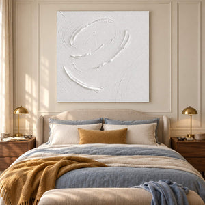 White minimalist relief painting with raised circular gestures without an outer frame in a bedroom.