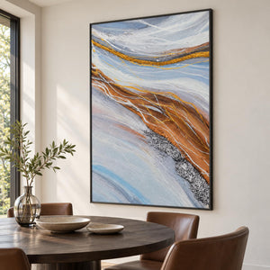 Artwork showing pale blue-gray bands curving around ochre areas with fine white lines in a dining area beside the table, with a black frame.