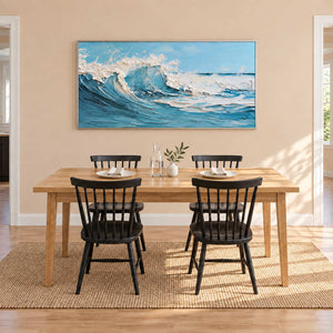 Foaming wave artwork behind a wooden dining table and black spindle-back chairs.