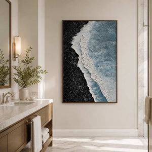 Wood framed shoreline abstract beside a marble bathroom vanity and leafy vase.