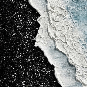 Close view of raised white shoreline ridges and tiny flecks against black.