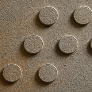 Close-up of raised circular relief and softly weathered blue-gray texture.