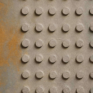 Detail of Small Stones in Rain, showing the raised circular forms and weathered gray texture.