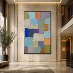 Textured color block painting displayed in a spacious contemporary hotel lobby.