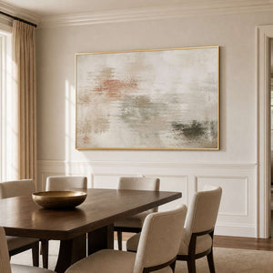 Ivory abstract wall art in a gold frame beside a dining table.