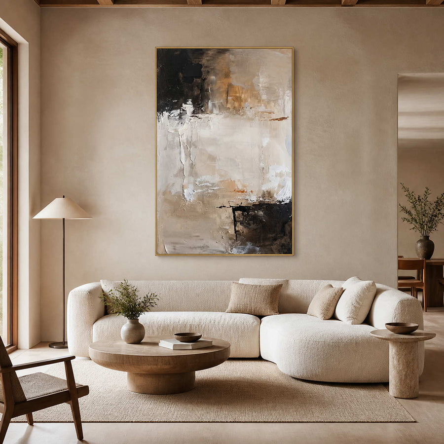 Beige abstract painting in a gold frame above a living room sofa.