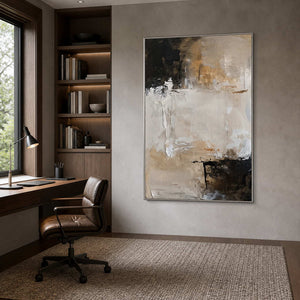 Silver framed neutral abstract painting beside a wooden desk in an office.
