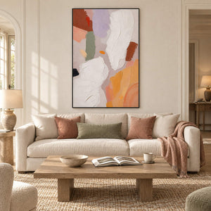 Abstract painting with ivory, lilac, sage, terracotta, and ochre forms in a black frame in a living room.