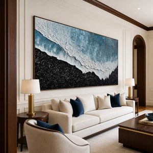 Wood framed coastal abstract above a cream sofa with deep blue accent cushions.