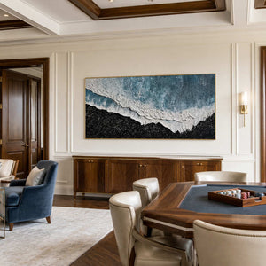 Gold framed panoramic shoreline abstract beside a card table in a recreation room.