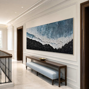 Silver framed coastal abstract along a stair landing above a pale blue bench.
