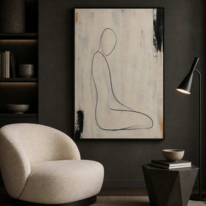 Ivory and black figurative wall art beside a quiet reading chair.
