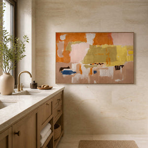 Wood framed warm abstract artwork beside a stone vanity in a bathroom dry area.