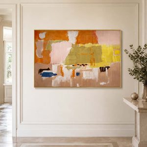Gold framed orange and blush abstract artwork on a bright paneled hallway wall.