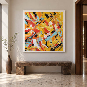 Artwork showing interlocking yellow, orange, light blue, white and black abstract strokes in an entryway above a console or bench, with no outer frame.