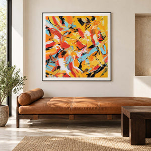Interlocking yellow, orange, light blue, white and black abstract strokes in an artwork with a black frame, displayed in a seating area.