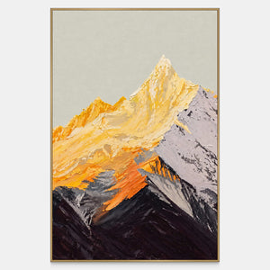 Vertical mountain artwork with golden-yellow peaks, a gray right slope and dark overlapping ridges beneath a pale sky, shown in a slim gold-colored frame.