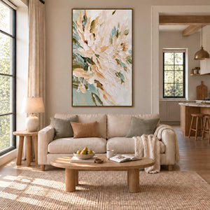 Tenderly in Bloom in a wood frame above a cream sofa with sage and tan cushions beside a large window.