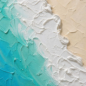 Close-up of turquoise water, white surf, and warm sand texture.