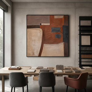 Black framed geometric artwork above a material sample table in an architecture studio.
