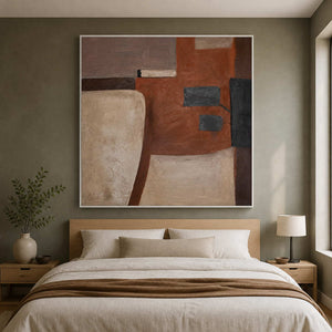 Square rust and beige abstract artwork in a white frame above a bed.