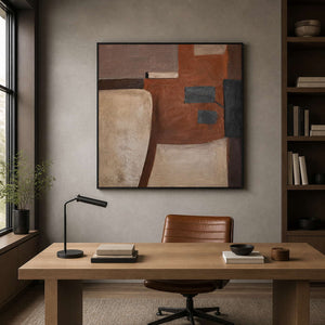 Black framed geometric painting displayed above a desk in a home study.