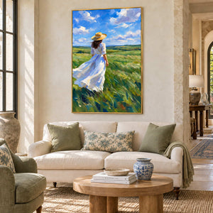 The Fields Await in a gold frame above a cream sofa with green cushions and an oval wood table in a lobby.