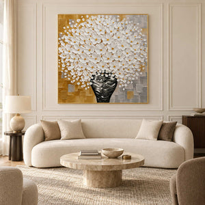 White bouquet artwork above a curved cream sofa in a pale paneled living room.