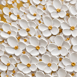 Close-up of rounded raised white petals and small golden-yellow flower centers.