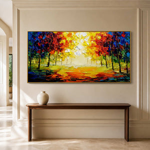 Gold-framed autumn woodland painting above a slim wooden console in a paneled hallway.